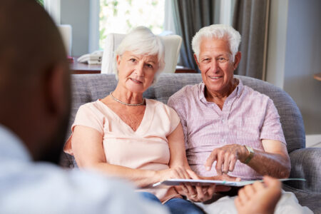 Happy senior couple taking financial advice at home